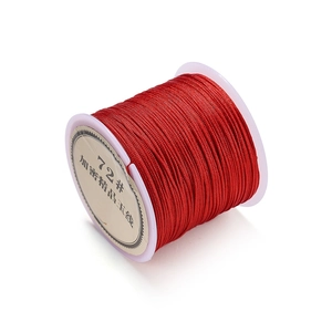 Detailed macro view of 0.8mm red braided cord on a transparent spool for DIY weaving