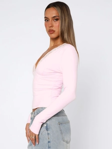 Close-up of pink V-neck top with delicate white lace trim and ribbed texture detail