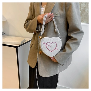 Dettaglio macro della borsa a cuore in strass argento con motivo freccia di cupido