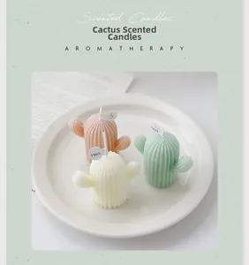 Vue détaillée de trois bougies parfumées cactus pastel en rose, blanc et vert sur un plateau