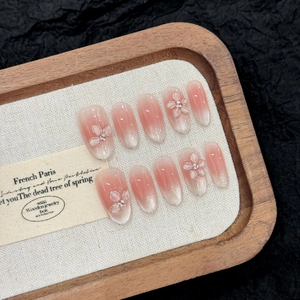 Pink and white gradient cat-eye press-on nails with 3D floral accents and rhinestones