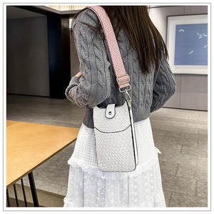 Detail der weißen Handytasche mit Webmuster und pinkfarbenem gemustertem Gurt