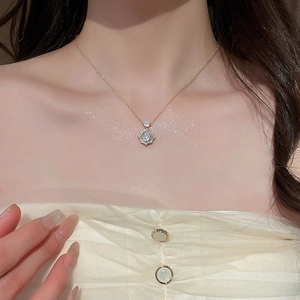 Detailed view of a 14k gold plated rose pendant necklace with sparkling zircons on a model