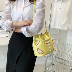 Lifestyle view of a yellow lemon fruit bucket bag with drawstring for women