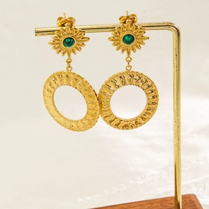 Detail of bohemian gold titanium earrings with green stone on a professional stand