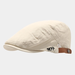 Retro cream canvas flat cap featuring black 1977 embroidery and brown leather strap