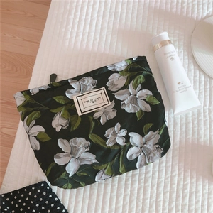 Detailed view of dark green jacquard floral canvas makeup bag with Time to Party label