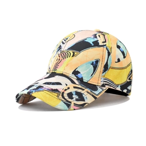 Detail view of cotton baseball cap featuring geometric graffiti print in bright orange and yellow