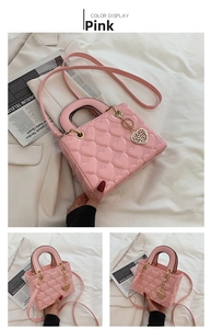 Detailed view of pink heart quilted handbag with metallic charm and shoulder strap.