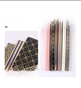 Detail of minimalist black plaid gift wrapping paper with gold foil geometric patterns