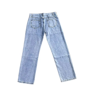 Detail view of the back pockets and washed texture on light blue denim jeans