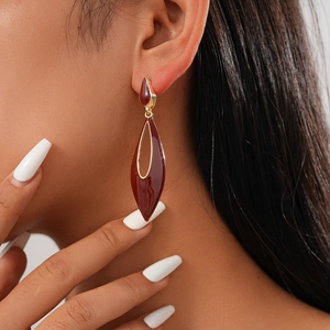 Close-up of vintage teardrop earrings with deep red enamel and gold-plated metal trim