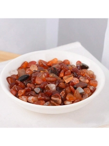 Close-up of polished natural red agate crystal stones in a white ceramic bowl on linen fabric
