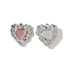 Macro detail of heart-shaped pink stone pendant with silver textured metal frame