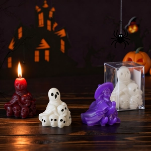 Ghost and witch candles set in resin molds on dark wood with warm Halloween lighting
