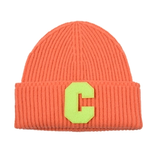 Detail of orange ribbed knit beanie with a bright neon green plush letter C patch