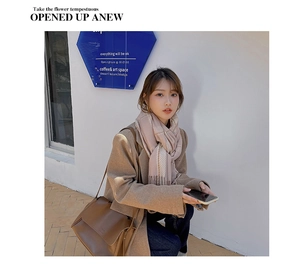 Close-up of pink plaid cashmere scarf with fringes styled with a brown leather handbag