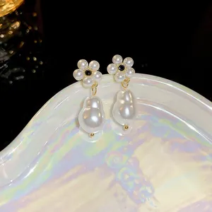 Macro detail of French style baroque pearl flower earrings with gold accents