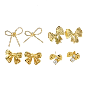 Set of four gold bow earrings with pearls and crystals in minimalist artistic style