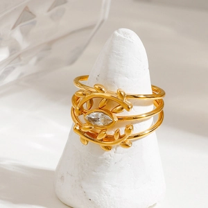 Close-up of golden olive leaf branch rings set with marquise cut zircon stones