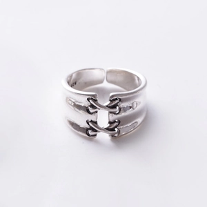 Close-up of silver vintage adjustable ring featuring cross-textured lace design and S925 stamp