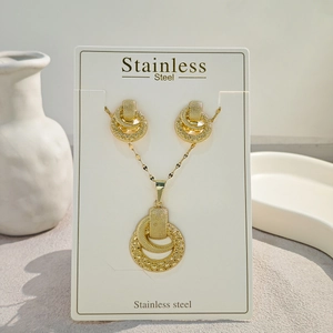 Golden stainless steel jewelry set featuring multilayered geometric circle pendant and earrings