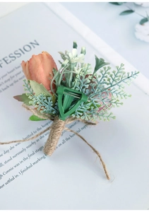 Detail of coral rose boutonniere with fern sprigs and jute twine wrapped stem