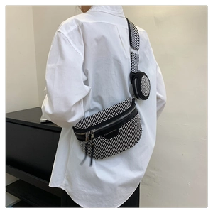 Detail of black crossbody chest bag with silver rivets and wide textured strap