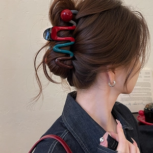 Tricolor wavy shark hair claw clip in red, green and brown resin on model hair