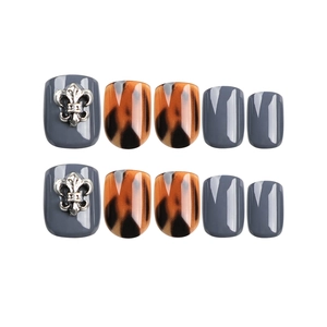Press-on nail set featuring dark grey tones, amber leopard print, and silver flower charms