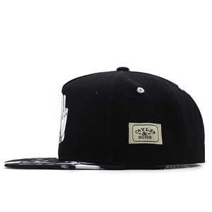 Black baseball cap with embroidered logo and black and white tie-dye patterned brim