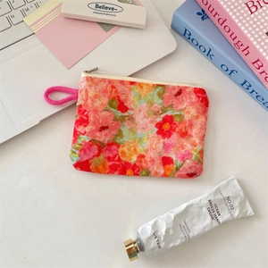 Floral makeup pouch on a desk with daily essentials in a bright lifestyle setting