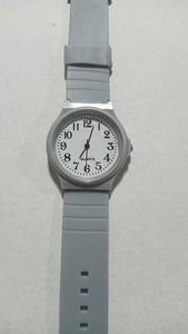 Macro view of grey quartz analog exam watch with a soft silicone strap and numeric dial