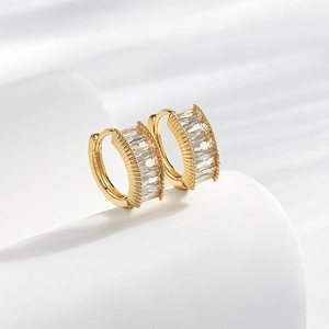 Elegant gold hoop earrings with baguette-cut zircons and fine vertical ribbed textures