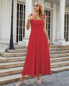 Détail d'une robe longue rouge à volants avec bustier smocké et bretelles nouées pour l'été
