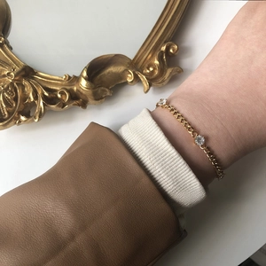Detail of 18K gold plated titanium chain bracelet with three sparkling white zircons