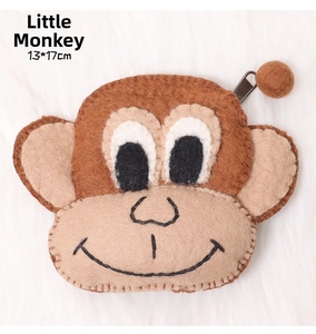 Detail of a monkey-shaped felt coin purse with metal zipper and soft fur background