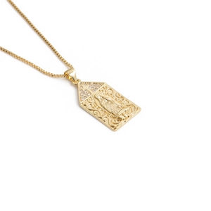 Detailed close-up of a gold necklace featuring a Mary pendant and a zircon cross