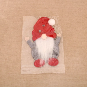 Close-up of a Christmas gnome cutlery holder with red knit hat and heart pattern detail