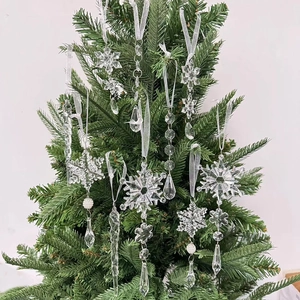 Dettaglio di fiocchi di neve e ghiaccioli in acrilico trasparente appesi all'albero di Natale