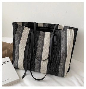 Close-up of woven fabric texture on striped tote bag with leather shoulder straps