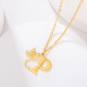 Detailed macro shot of a golden letter P pendant featuring a side face silhouette design