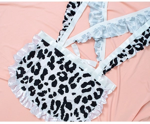 Detailed flat lay of leopard print lingerie with white satin ruffles and crisscross straps