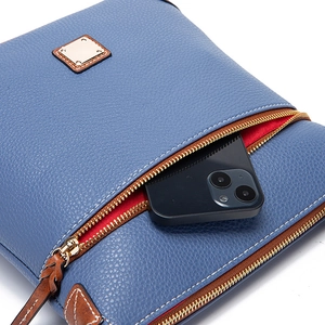 Detail of blue pebble grain leather bag with gold zipper and red lining for phone storage