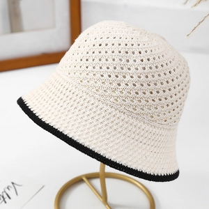 Detailed close-up of beige crochet sun hat featuring contrast black trim and knit texture
