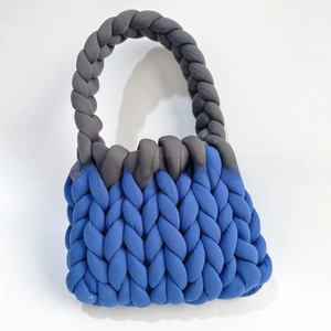 Detail of chunky handmade knit bag showing blue and grey braided cotton yarn texture