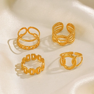 4-piece set of gold stainless steel crossover and chain rings on beige silk