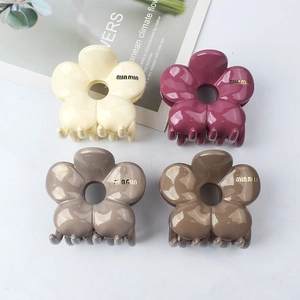 Polished flower hair claws in four colors including cream and rose with golden branding