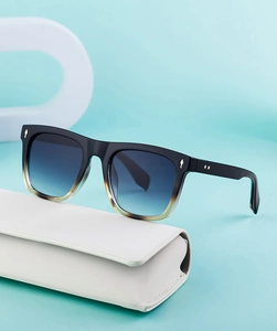 Detail of square sunglasses with gold studs on a premium white faux leather protective case