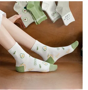 Detail of white cotton socks with green avocado and fried egg patterns for women
